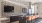 Common area at our Alexandria apartments featuring seating, grey countertops, and two flat screen TVs.